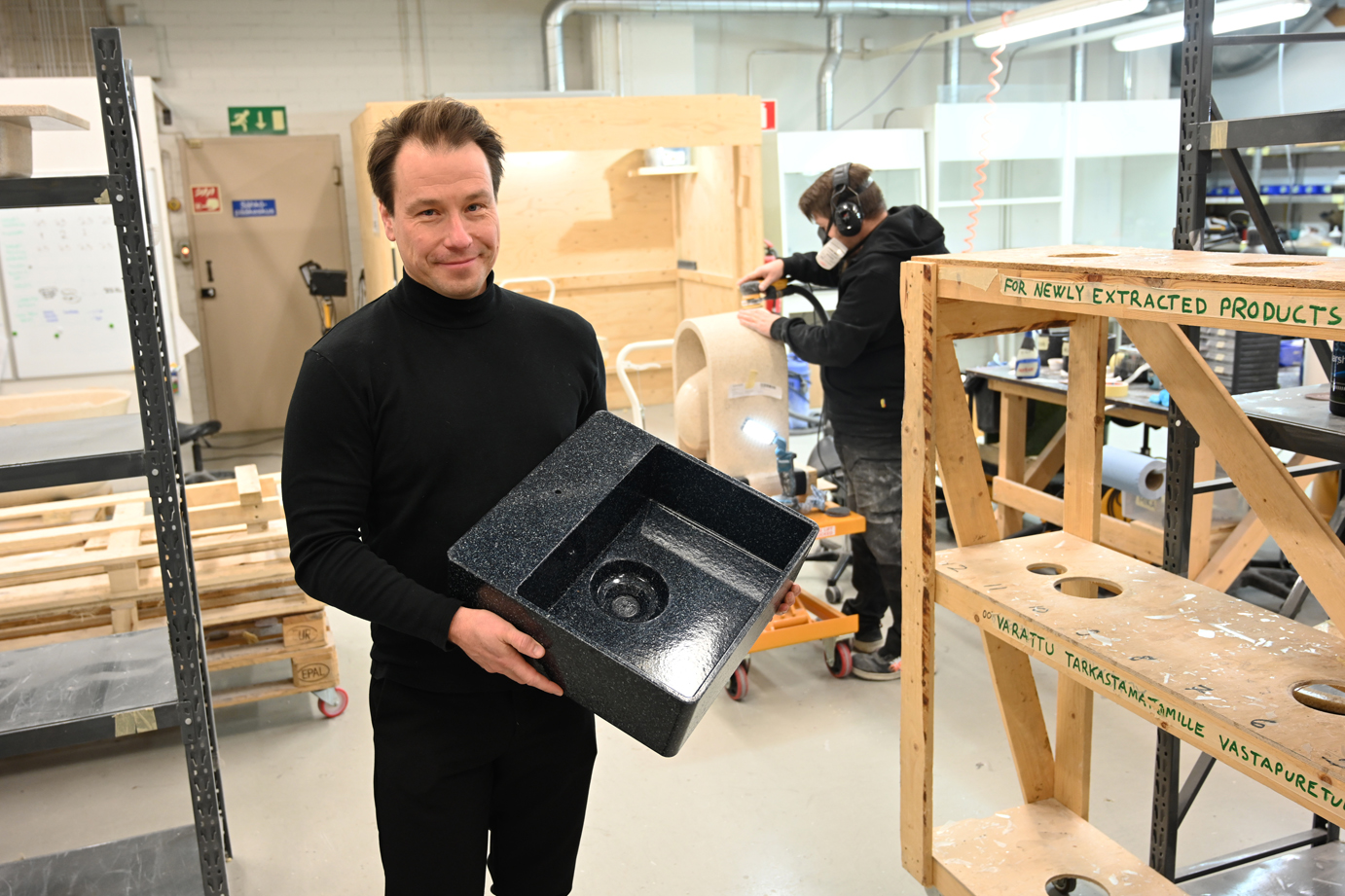 1 Woodio CEO Petro Lahtinen showing a kitchen sink made from wood chips