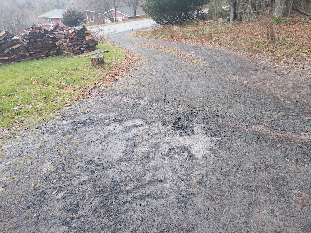 Wood ash spread on a gravel driveway above a water bar.