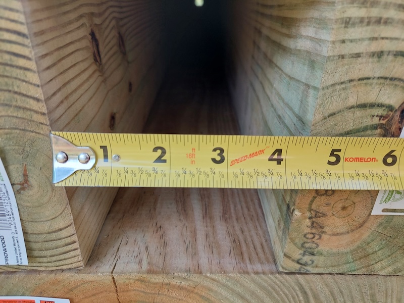 A tape measure measuring the width inside the culvert’s two side walls.