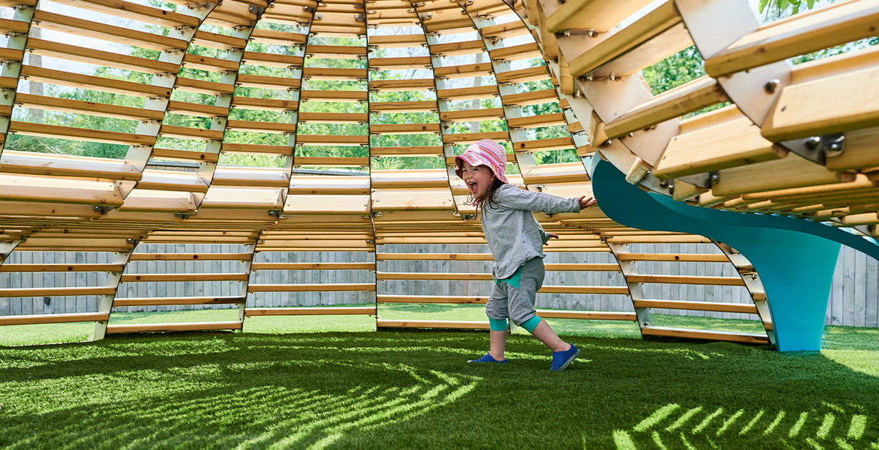 A child delighted by the NEST playscape at the Brooklyn Children’s Museum. 