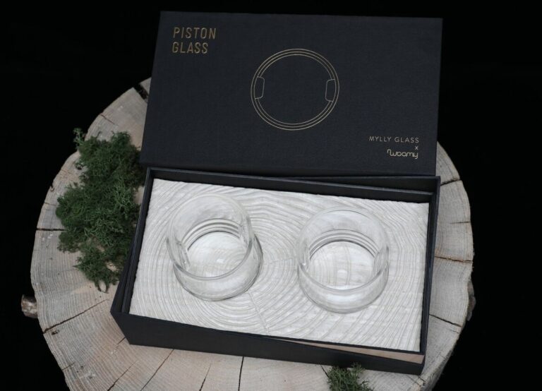 A photo of a set of glasses in a smooth black cardboard box packaged in protective bio-based foam. 