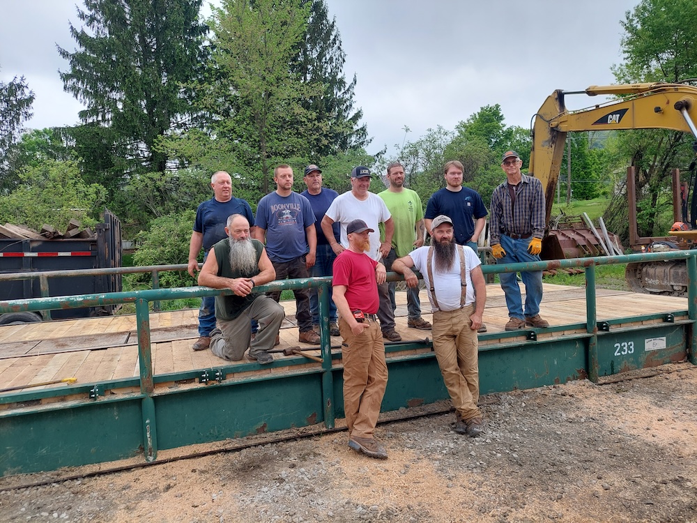 A group of men pose for a photo on the bridge after a job well done.